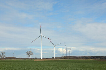 Modern wind turbines in field on sunny day. Alternative energy source