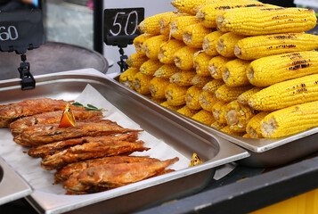 Baked corn and fish at the fair. The concept of street food.