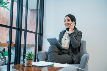 busy muslim businesswoman making a phone call while working in the office by her self