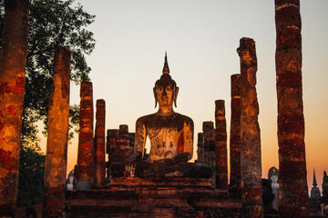 Sunset at Wat Mahathat buddha and temple in Sukhothai Historical Park - obrazy, fototapety, plakaty