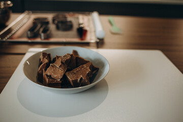 dark chocolate chunks in wooden bowl, on oak table