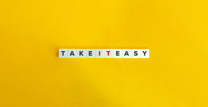 Take It Easy Idiom on Letter Tiles on Yellow Background. Minimal Aesthetics.