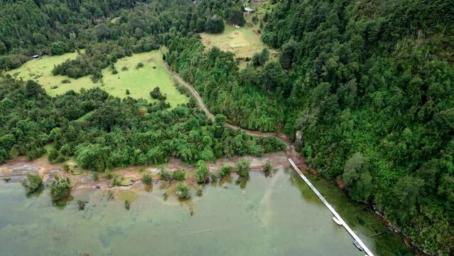 Pan right tilt down aerial view of a small port on Tagua Tagua Lake, southern Chile.