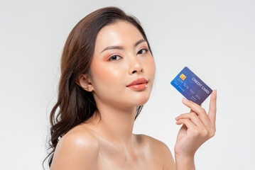 Beautiful Asian woman client with credit card in hand while standing on white isolated background