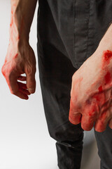 Man in black pants with bloody hands isolated on white background. Hands of a murderer and a rapist.