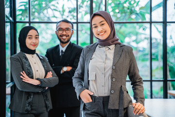 beautiful muslim businesswoman leader as she standing in front of her team smiling proudly to camera