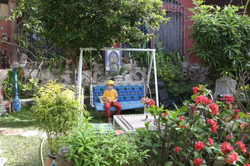 Vacationer, child in cozy swing. Rest, recreation in garden on Ngor island, Senegal, Africa....