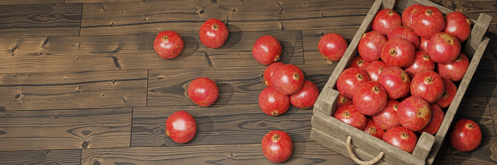 pomegranates, juicy fruits in a wooden crate on wooden background banner