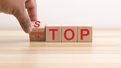 Doctor hand flip wood block stacking with stop covid-19 text, coronavirus health care, insurance for your health.