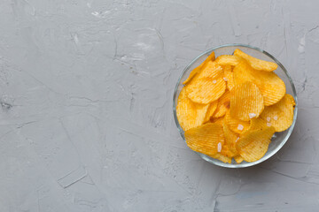 Potato chips on bowl isolated on colored background. Delicious crispy potato chips in bowl. Space for text. Top view