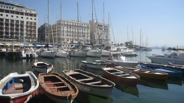 Scenic video clip of boats moored in ocean with Santa Lucia waterfront in background, Naples, Italy. 