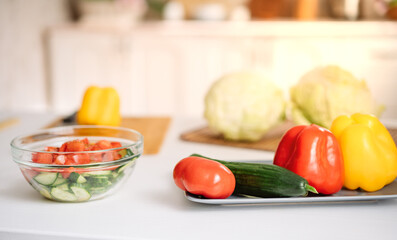 strengthening immunity during the coronavirus pandemic. Fresh vegetables on the table against the background of a white kitchen. Kale cabbage, tomatoes, cucumbers, paprika, cabbage. Beriberi.