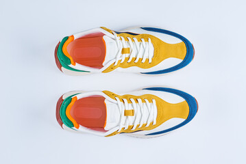 Pair of stylish colorful youth sneakers on white background, Sport trendy shoes, top view