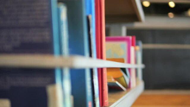 Student woman taking book from shelf in library. 4K Slowmotion Educational Concept Footage.