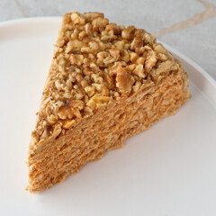 Close-up, piece of cake with condensed milk on a white plate.