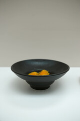 Beautiful beige and black plates. Dandelion flower in vase. Table design. Minimal decor