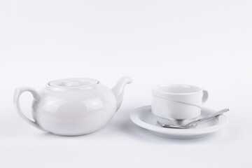 white porcelain teapot and cup on saucer for coffee or tea empty