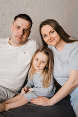 Portrait of loving family with infant daughter. Happy caucasian family of three people. Selective focus. Film grain