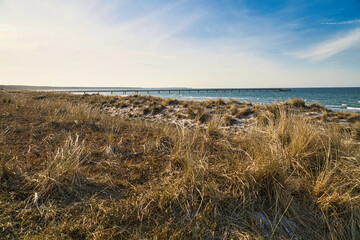 on the beach of the baltic sea with clouds, dunes and beach. Hiking in spring.