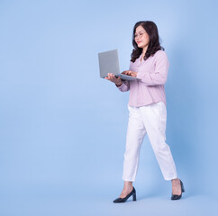 Full length image of middle aged Asian woman on blue background