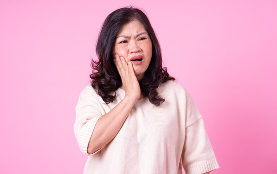 Image of middle aged Asian woman on pink background