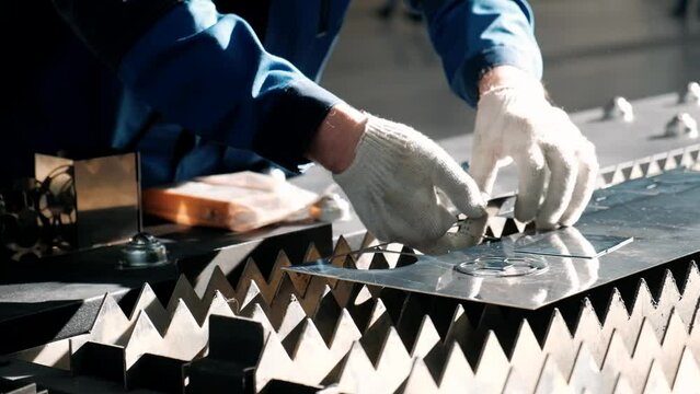 A worker works with a robotic laser machine