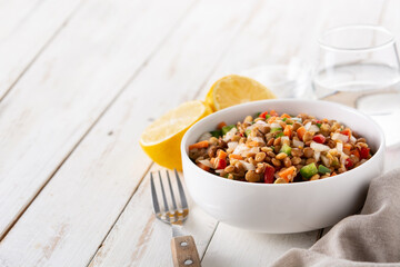 Lentil salad with peppers,onion and carrot in bowl on wooden table. Copy space