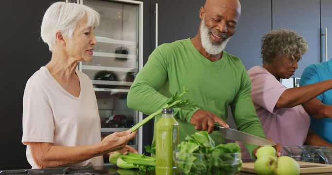 Happy Senior Diverse People Cooking In Kitchen At Retirement Home