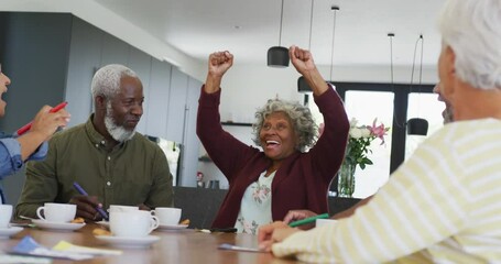 Happy senior diverse people drinking tea and playing bingo at retirement home - Powered by Adobe