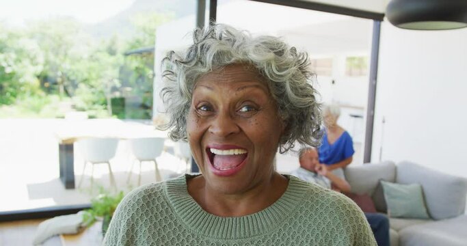 Portrait of happy senior african american woman with other seniors at retirement home