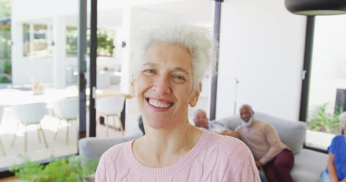 Portrait of happy senior caucasian woman with other seniors at retirement home