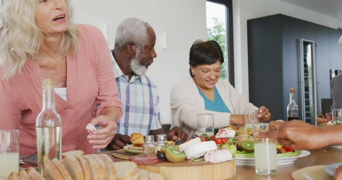 Happy senior diverse people having dinner at retirement home