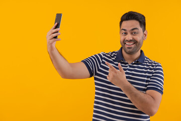 Portrait of happy young man taking selfie by using Smartphone