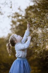 Dziewczynka zaciekawiona wiosennym drzewem - obrazy, fototapety, plakaty