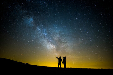 Naklejka na ściany i meble Milky way and couple in Serra Del Montsec, Lleida, Spain