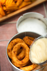 Deep fried onion rings with mayonnaise sauce and glass of beer - traditional pub drinks and beer snack