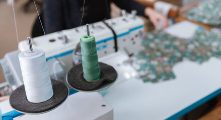 Close-up spool of multicolored threads for sewing machine. Concept Interior of garment factory