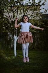 Fototapeta Dziewczynka w sukience wysoko skacze obraz