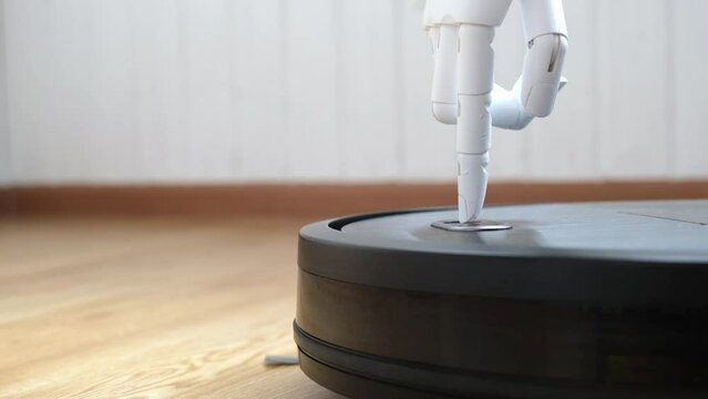 People with special needs. The prosthetic hand presses the button of the robot vacuum cleaner. The concept of doing housework by a disabled person. Loss of a limb, prosthetics. Manufacturability of