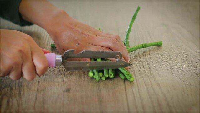 People cutting Yard long beans on wooden cutting board for cooking meals