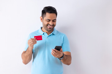 Portrait of a young man shopping online through Smartphone using credit card 