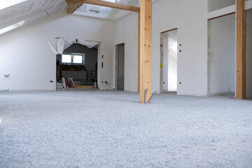 Construction site of attic conversion in the phase of floor screed fill and drywall is already in place and already partially spackled