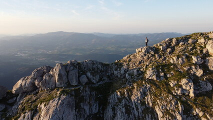 man standing on the top of a mountain at sunset in Urkiola Natural Park in the Basque Country, Spain