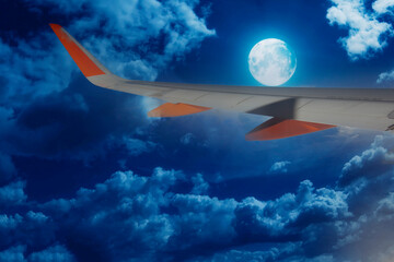 Fototapeta na wymiar airplane wing in flight on a clear night with the moon-