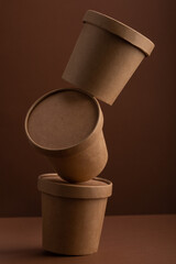 Balanced brown crafted paper cup for soup on grey background. Eco package. Zero Waste. Mock up for branding.