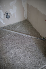 Construction site of attic conversion in the phase of floor screed fill and drywall is already in place and already partially spackled