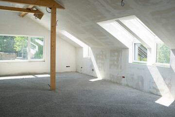 Construction site of attic conversion in the phase of floor screed fill and drywall is already in...