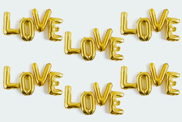 Inscription LOVE foil inflatable golden ballon on the white background. Love, romance and Valentines day background. Flat lay