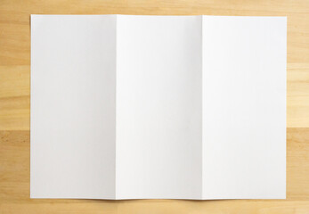 White folded paper on wood table background