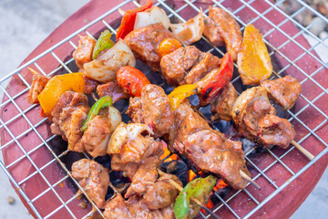 Barbecue skewers meat with vegetables on grill close up